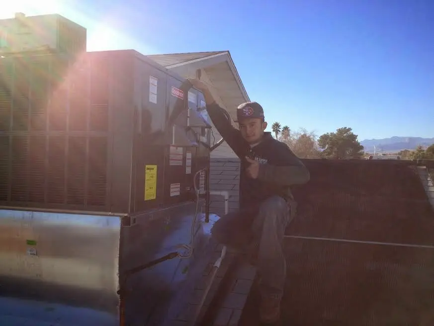 HVAC technician performing AC Tune-Up on a rooftop unit in Norwalk