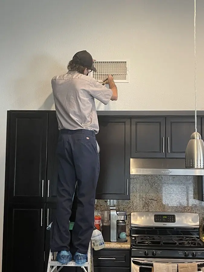 Technician inspecting an air vent during HVAC service in Norwalk